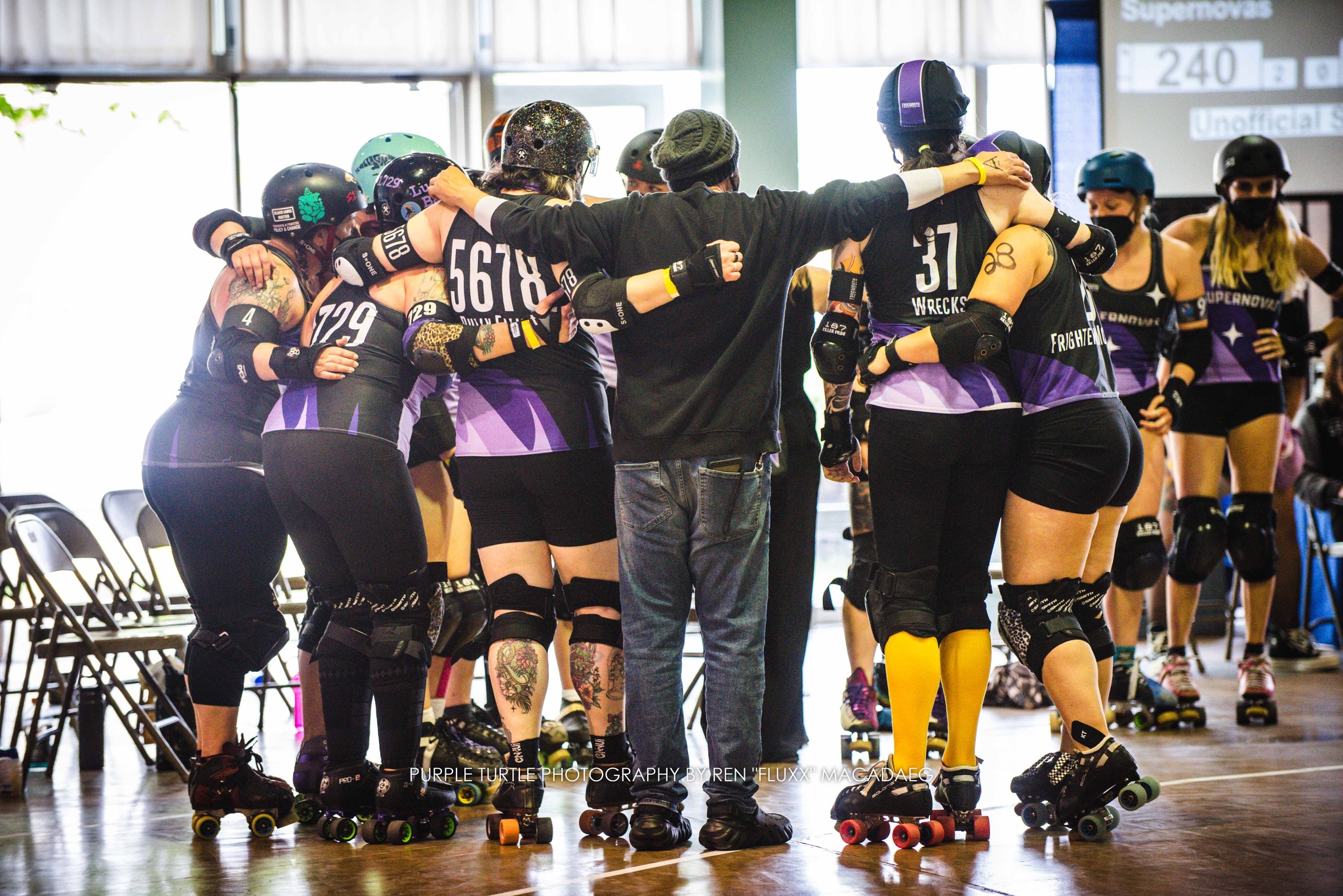 Photo by Purple Turtle Photo. Novas huddle up with coaching after a win.